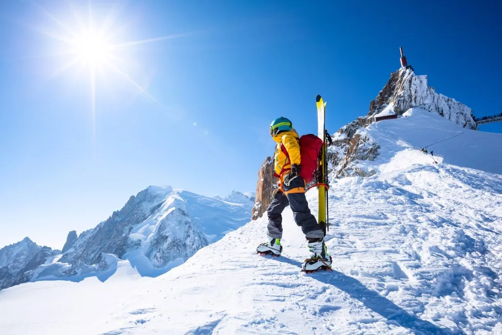 A skier is standing on the mountain top.
