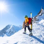 A skier is standing on the mountain top.