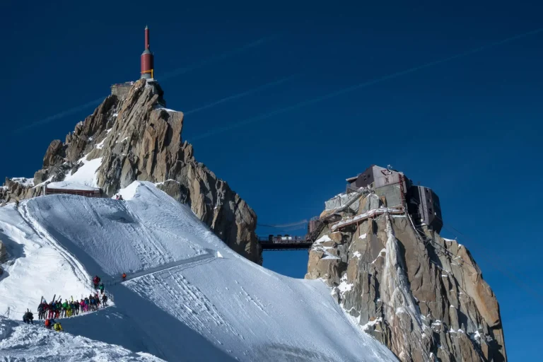 Line of skiers on Aiguille du Midi ridge in winter