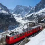 Montenvers train (cogwheel train) with Les Grandes Jorasses peaks and Mer de Glace glacier. View of Vallee Blanche (winter ski resort) of the Mont Blanc massif, Alps, Haute-Savoie, France