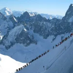 Skiers descending mountain ridge above Chamonix